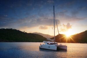 A boat is sailing on the water at sunset.