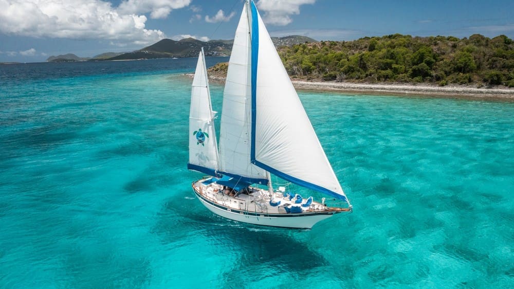Sailboat cruising in calm, clear water in the Virgin Islands