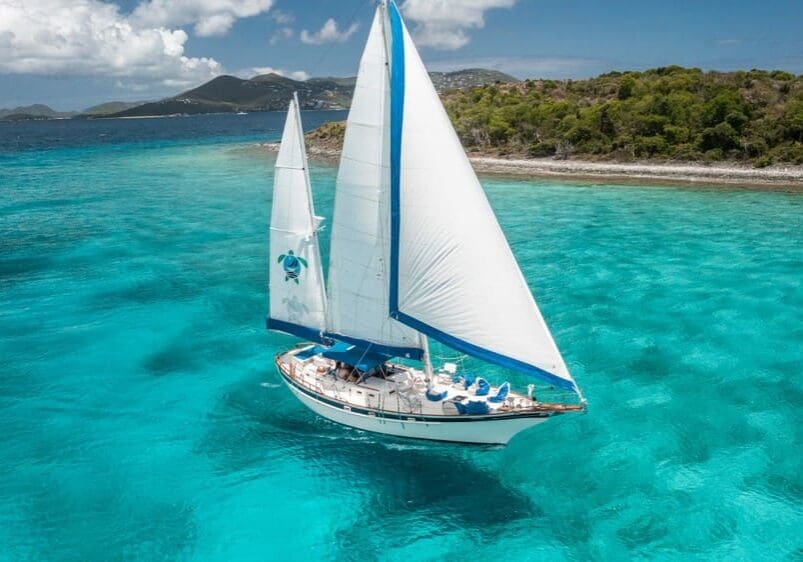 Sailboat cruising in calm, clear water in the Virgin Islands
